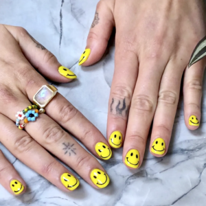 Yellow smiley face nails.