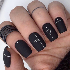 Geometric designs on black nails. 