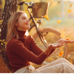 Woman throwing autumn leaves. 