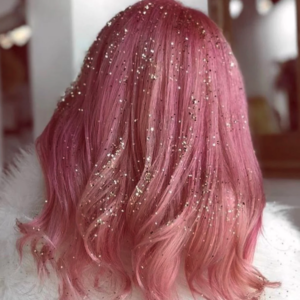 Medium-length, light pink hair covered in gold and silver glitter. 