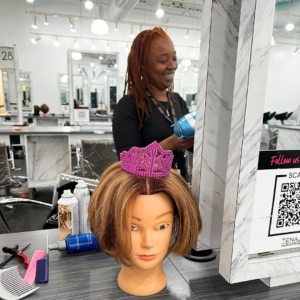 Cosmetology student a work with mannequin on display. 